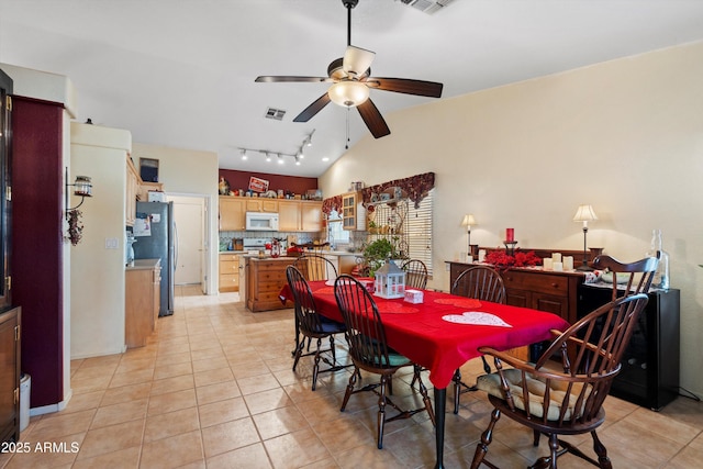 dining room featuring lofted ceiling, light tile patterned floors, and ceiling fan