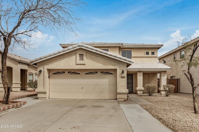 view of front of property with a garage, a tiled roof, concrete driveway, and stucco siding