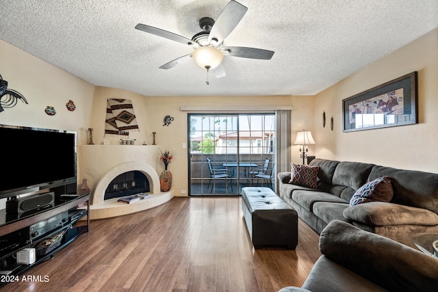 living room featuring ceiling fan, a textured ceiling, and hardwood / wood-style floors