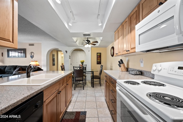 kitchen featuring track lighting, sink, white appliances, light tile patterned floors, and ceiling fan