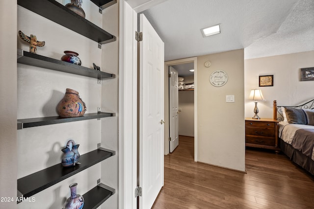 bedroom featuring a textured ceiling and dark hardwood / wood-style flooring