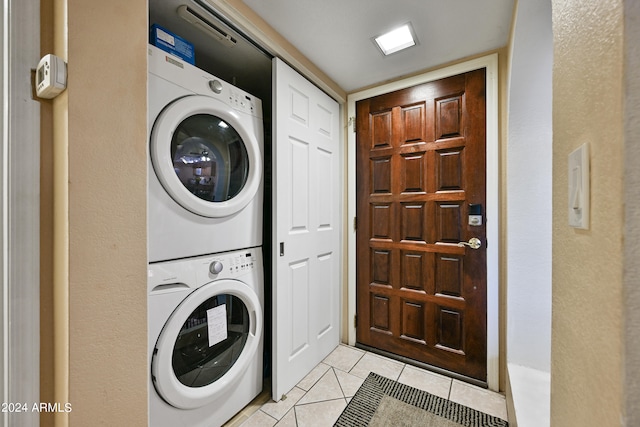 washroom featuring stacked washing maching and dryer and light tile patterned floors