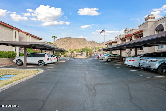 view of vehicle parking with a mountain view and a carport