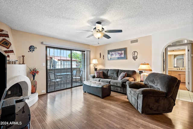 living room with ceiling fan, a textured ceiling, hardwood / wood-style floors, and sink