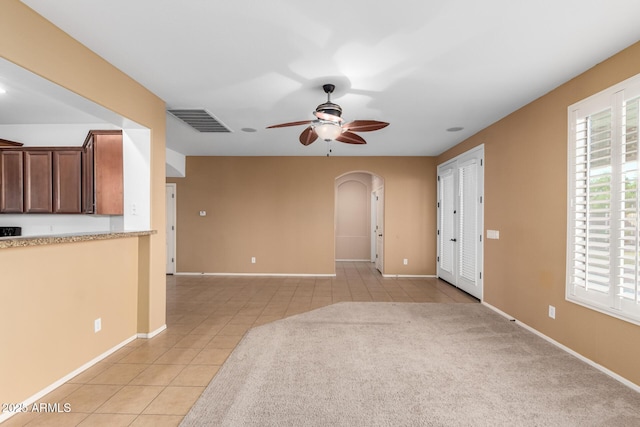 unfurnished living room featuring ceiling fan and light tile patterned floors