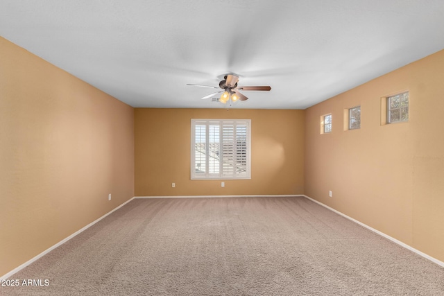 carpeted spare room with ceiling fan