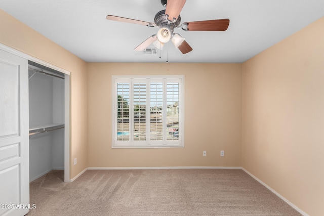 unfurnished bedroom with ceiling fan, light colored carpet, and a closet