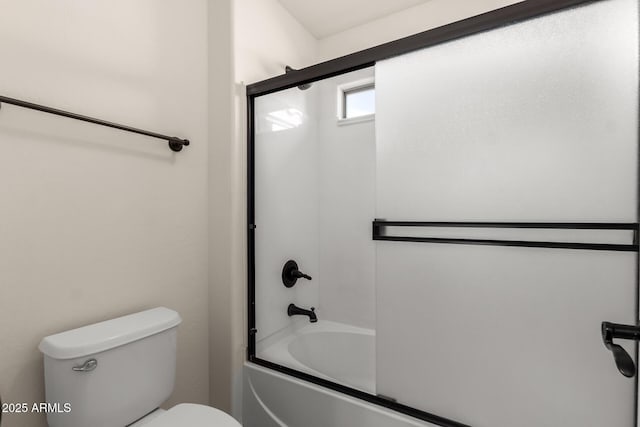 bathroom featuring enclosed tub / shower combo and toilet