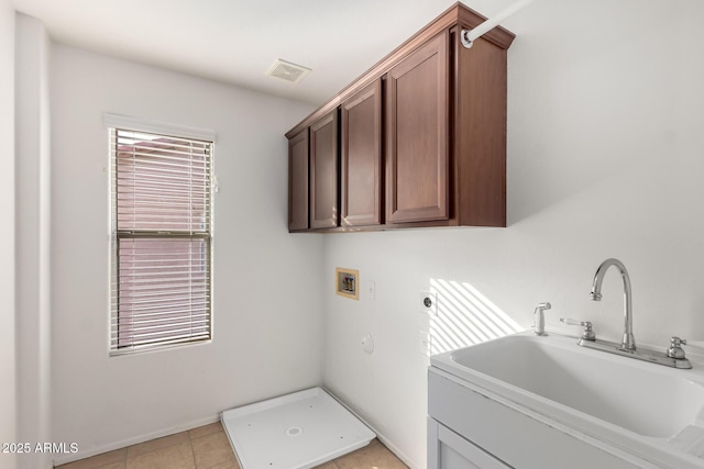 washroom with sink, washer hookup, light tile patterned floors, electric dryer hookup, and cabinets