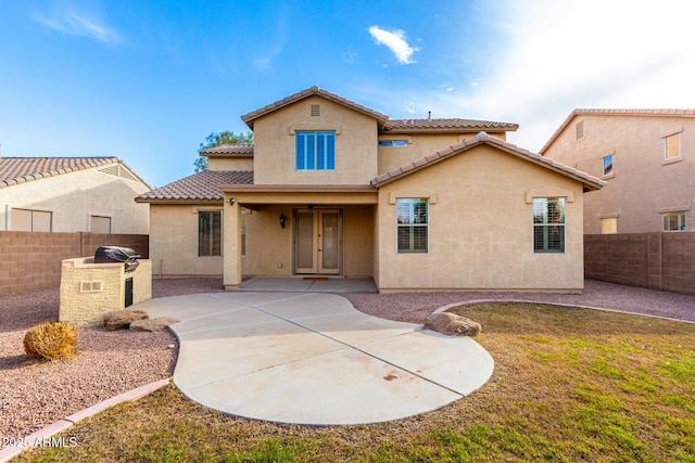 back of house with an outdoor kitchen and a patio