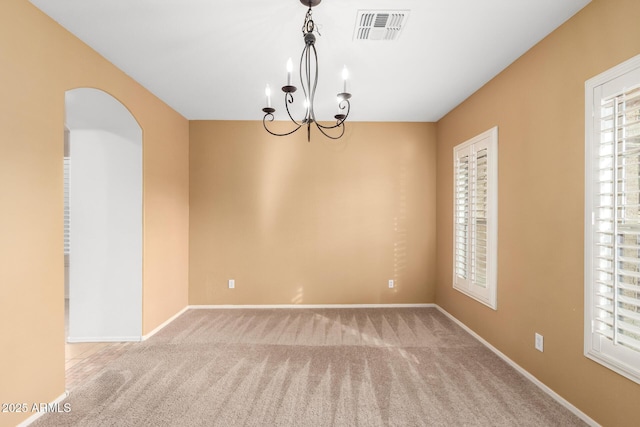 unfurnished room with light carpet and a notable chandelier