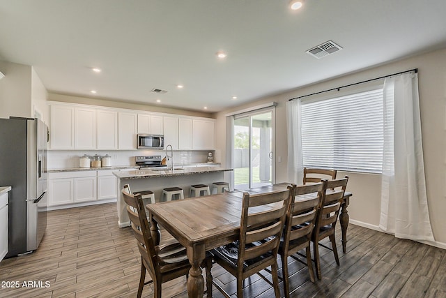 dining space with baseboards, visible vents, recessed lighting, and light wood-style floors