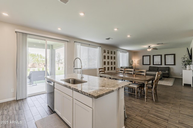 kitchen featuring dishwasher, a ceiling fan, a sink, a center island with sink, and open floor plan