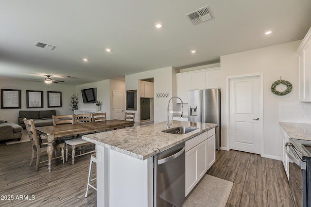 kitchen with dark wood finished floors, visible vents, stainless steel appliances, and a sink