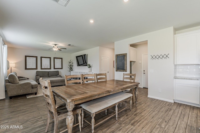 dining room with wood finished floors, visible vents, baseboards, and ceiling fan