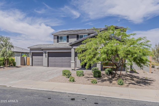 view of front of property featuring stucco siding, an attached garage, fence, and decorative driveway