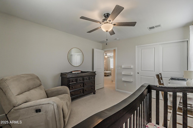 carpeted bedroom featuring a closet, visible vents, and a ceiling fan