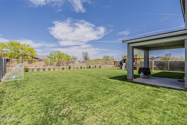 view of yard with a fenced backyard, a patio area, and a playground