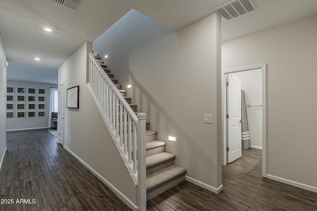 stairway featuring wood finished floors, visible vents, and baseboards