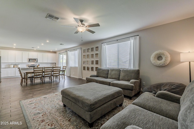 living room featuring a ceiling fan, wood finished floors, visible vents, and recessed lighting
