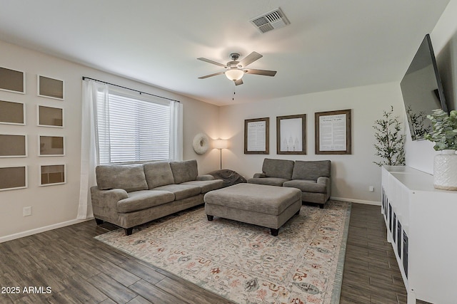 living room with baseboards, a ceiling fan, visible vents, and dark wood-style flooring