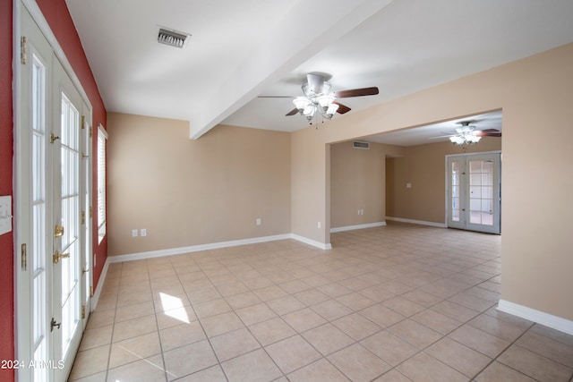 spare room featuring ceiling fan, beamed ceiling, plenty of natural light, and light tile patterned floors