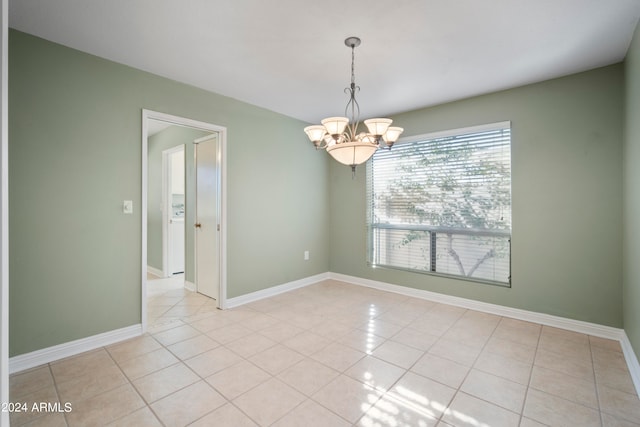 unfurnished room featuring an inviting chandelier and light tile patterned floors