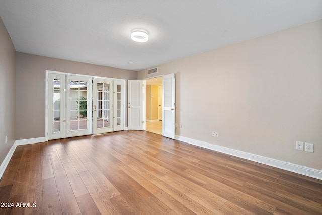 unfurnished room with light hardwood / wood-style floors and french doors