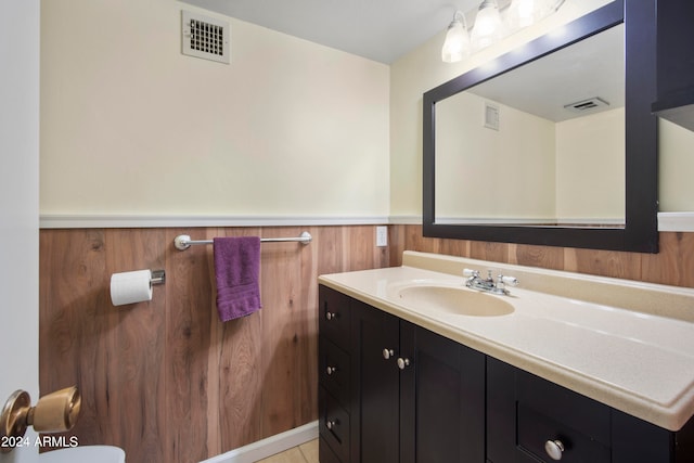 bathroom with vanity, wood walls, and tile patterned floors