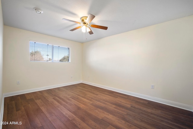 empty room with ceiling fan and dark hardwood / wood-style flooring