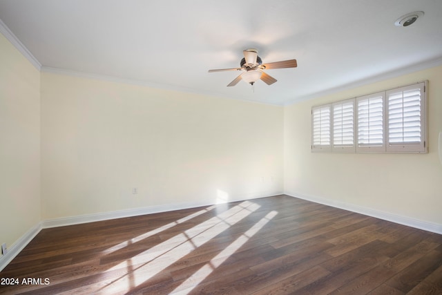 spare room with dark wood-type flooring, crown molding, and ceiling fan