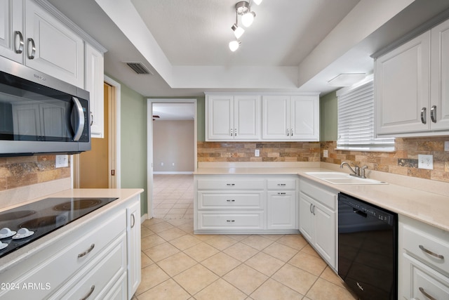 kitchen with light tile patterned floors, backsplash, white cabinetry, black appliances, and sink