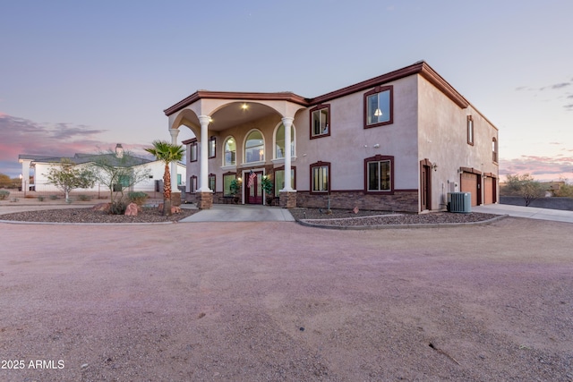 mediterranean / spanish home featuring a garage and central AC unit