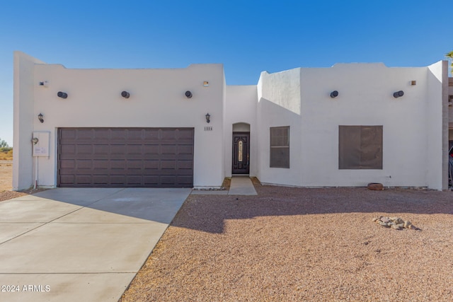 pueblo revival-style home featuring a garage