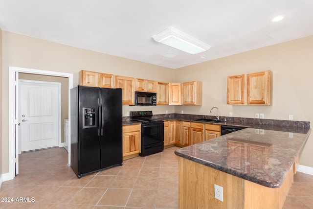 kitchen featuring kitchen peninsula, sink, black appliances, light tile patterned floors, and dark stone countertops