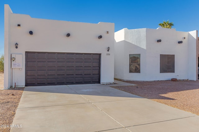 pueblo-style house featuring a garage