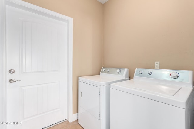 clothes washing area featuring independent washer and dryer and light tile patterned flooring