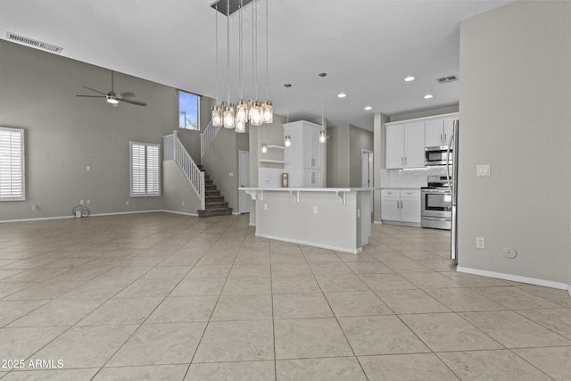 1162 E Ranch Ct, Gilbert, AZ 85296 - kitchen featuring stainless steel appliances, a breakfast bar, open floor plan, light tile patterned floors, and recessed lighting