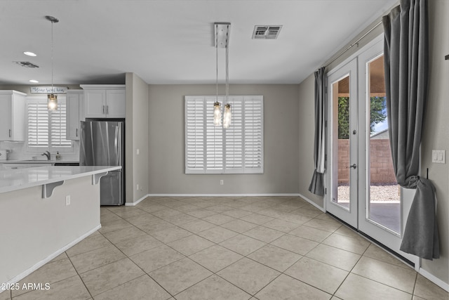 1162 E Ranch Ct, Gilbert, AZ 85296 - kitchen featuring freestanding refrigerator, french doors, light countertops, a breakfast bar, and healthy amount of natural light