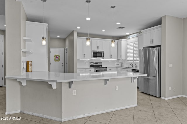 1162 E Ranch Ct, Gilbert, AZ 85296 - kitchen with appliances with stainless steel finishes, a peninsula, light tile patterned flooring, white cabinets, and recessed lighting