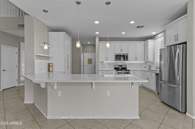 1162 E Ranch Ct, Gilbert, AZ 85296 - kitchen with appliances with stainless steel finishes, a peninsula, decorative backsplash, a breakfast bar, and recessed lighting