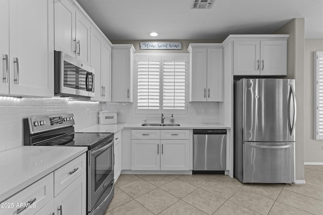 1162 E Ranch Ct, Gilbert, AZ 85296 - kitchen with stainless steel appliances, a sink, white cabinetry, light countertops, and tasteful backsplash
