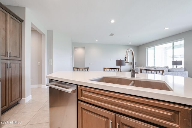 kitchen featuring sink, stainless steel dishwasher, and light tile patterned floors