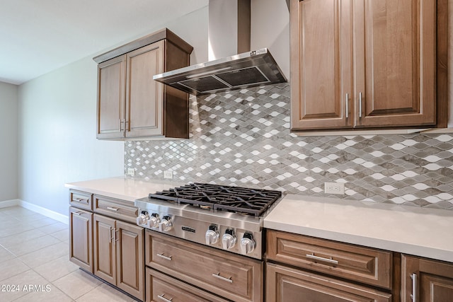 kitchen featuring backsplash, light tile patterned floors, wall chimney exhaust hood, and stainless steel gas cooktop