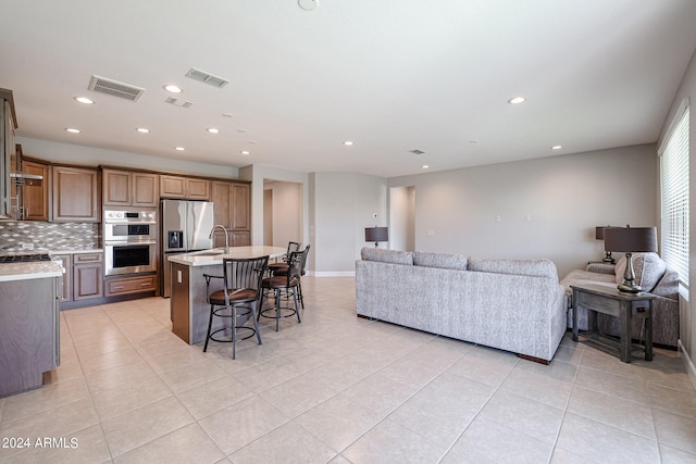 living room featuring sink and light tile patterned flooring