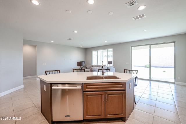 kitchen with sink, stainless steel dishwasher, a center island with sink, and light tile patterned floors