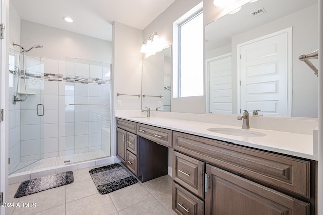 bathroom with tile patterned floors, double vanity, and an enclosed shower