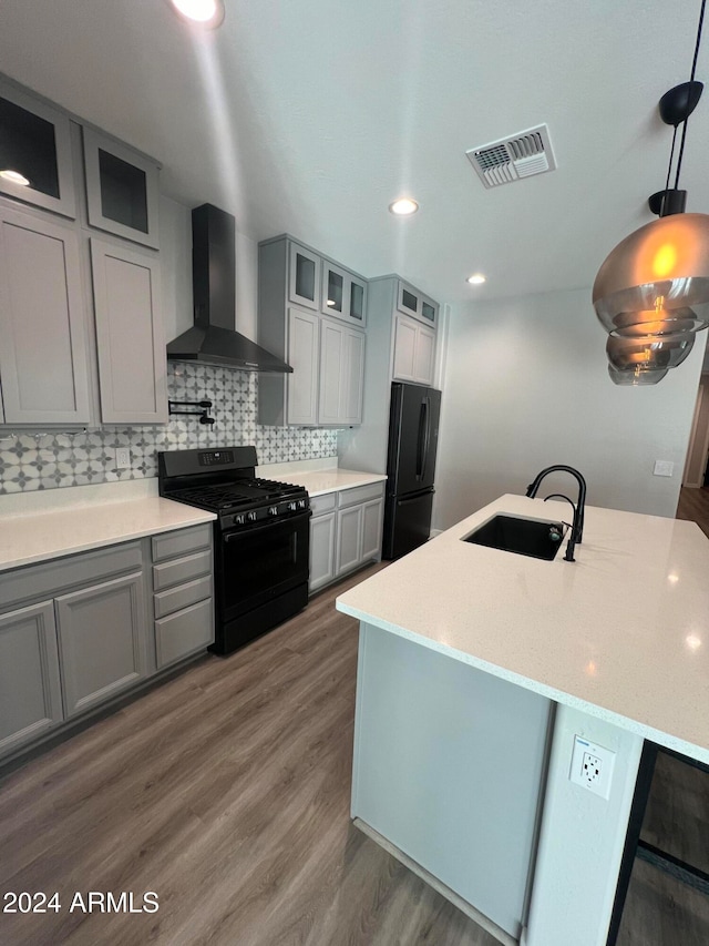 kitchen with tasteful backsplash, wall chimney range hood, sink, black appliances, and dark hardwood / wood-style floors