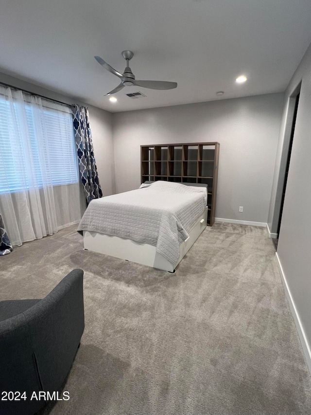 bedroom with ceiling fan and light carpet