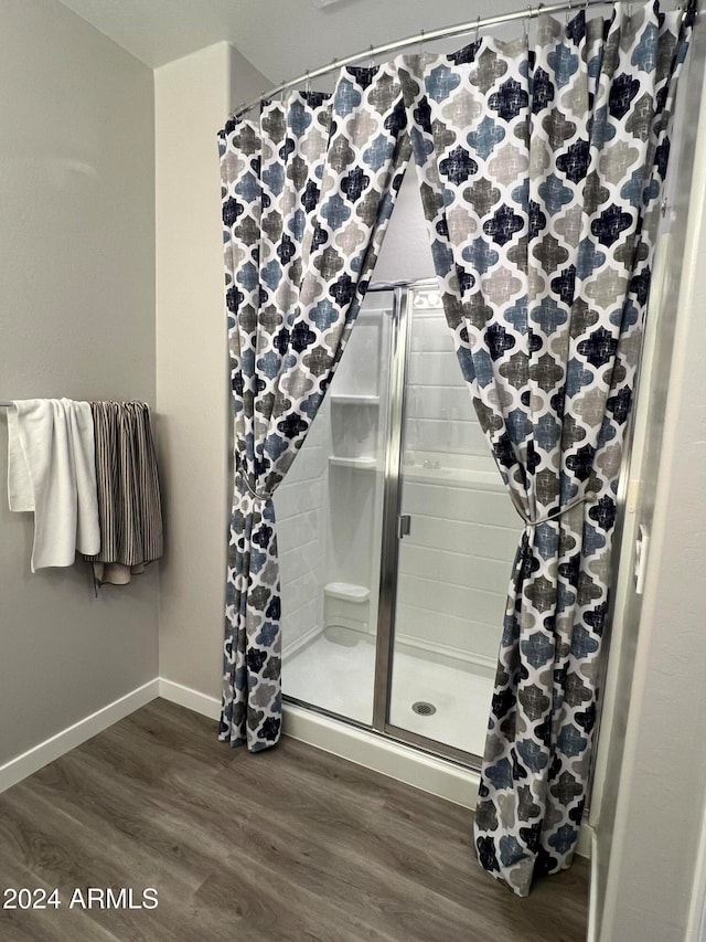 bathroom with a shower with shower curtain and hardwood / wood-style flooring